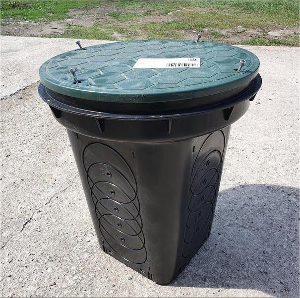 Čierna plastová rozdeľovacia šachta AQR so zeleným poklopom umiestnená na betónovom podklade.