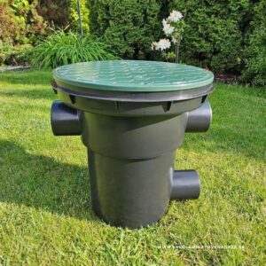 Filtračná šachta ŠTANDARD na mechanické čistenie dažďovej vody pred vtečením do nádrže, čierne telo so zeleným poklopom v trávniku.